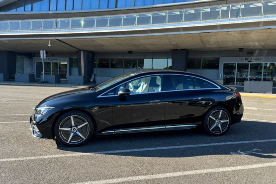 Vue de profil d’une berline noire de Centrale VTC Toulouse devant le terminal de Toulouse-Blagnac.